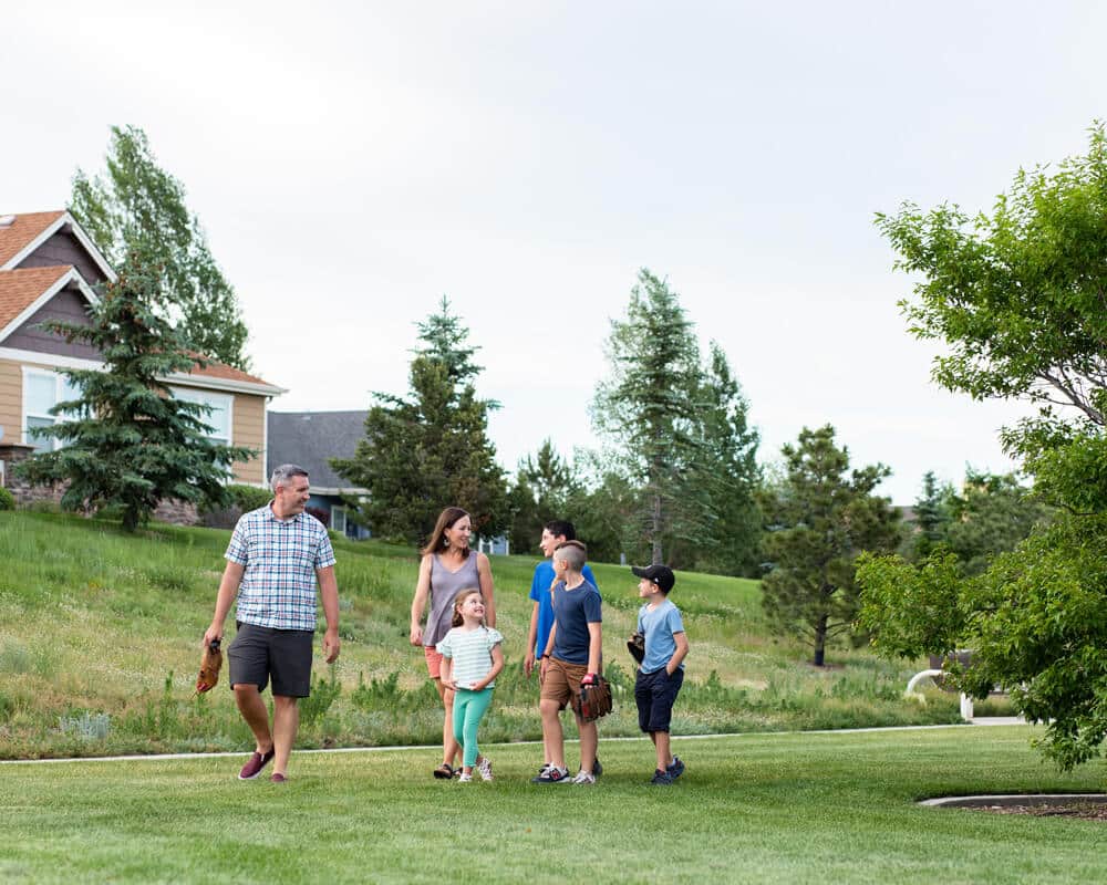 A family enjoying a walk through a green neighborhood park.